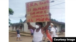 Juan Enrique Pérez Sánchez en la manifestación del 11 de julio de 2021 en el poblado Vegas. En la protesta portaba un cartel que decía: "Era tanta el hambre que nos comimos el miedo".